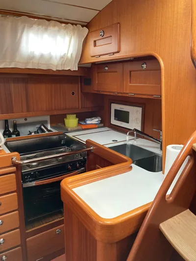 Morgan's Moon Yacht Photos Pics 2008 Hallberg-Rassy 43 yacht kitchen with wood cabinetry, stove, and sink.