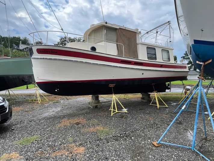 Charley's Tern Yacht Photos Pics 1998 Nordic Tug 32 boat on stands, displayed outdoors under cloudy sky.