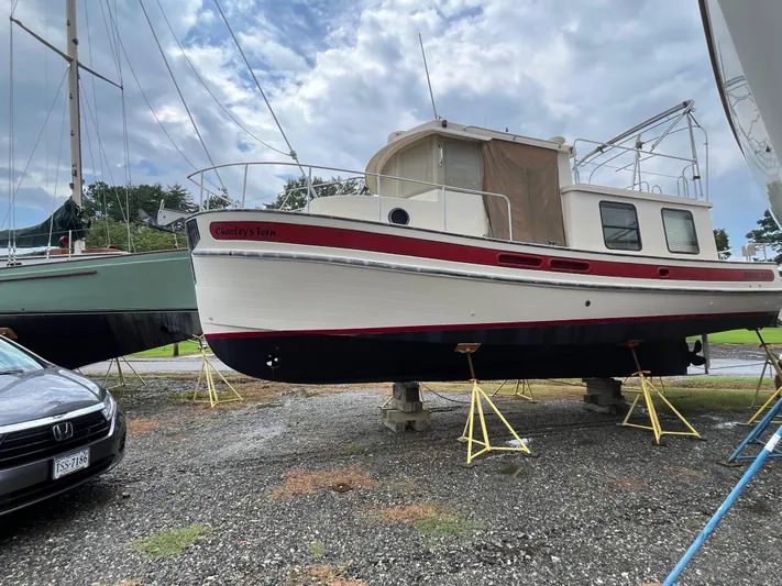 Charley's Tern Yacht Photos Pics 1998 Nordic Tug 32 boat on stands, with overcast sky and nearby vehicles.