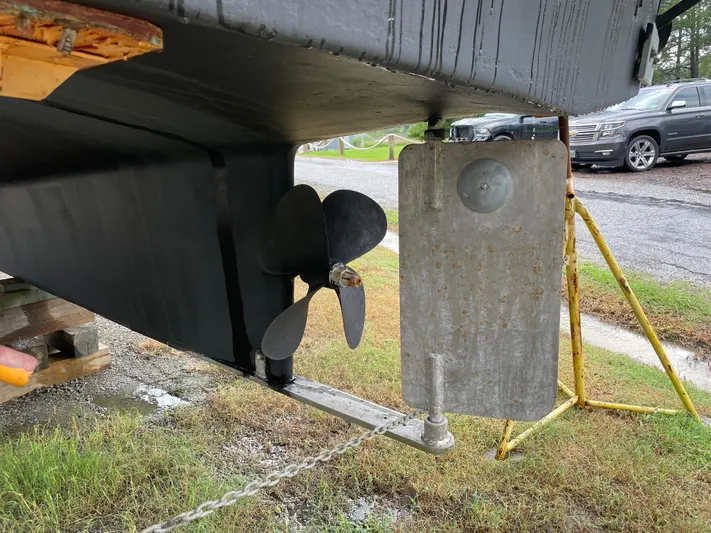 Charley's Tern Yacht Photos Pics 1998 Nordic Tug 32 propeller and rudder detail, displayed on a stand outdoors.