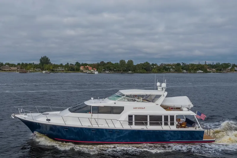  Yacht Photos Pics 2000 Pacific Mariner 65 Motoryacht cruising on a calm waterway under cloudy skies.