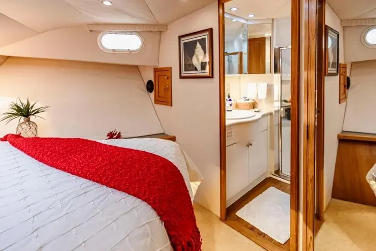  Yacht Photos Pics Luxurious 2000 Pacific Mariner 65 Motoryacht bedroom with ensuite bathroom, red accents, and elegant decor.