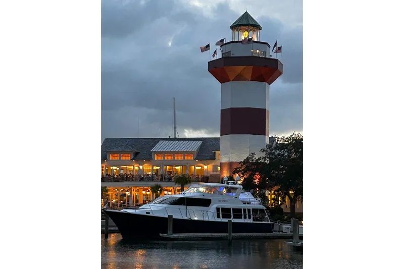  Yacht Photos Pics Pacific Mariner 65 Motoryacht docked near a lighthouse at dusk, 2000 model.