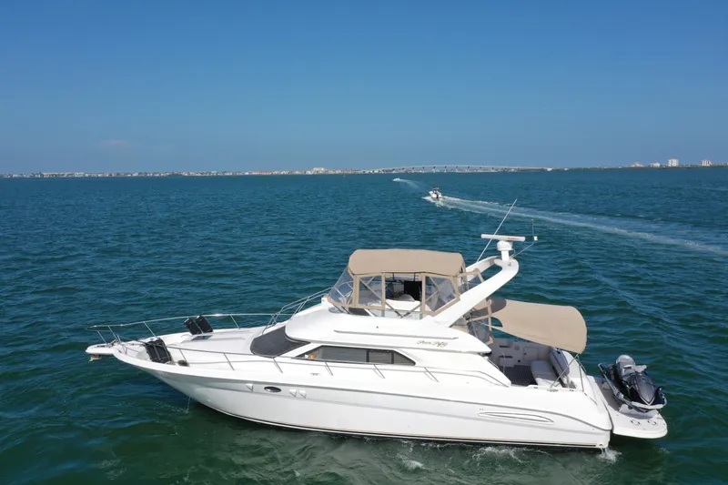 Livin' The Dream Yacht Photos Pics 2001 Sea Ray 450 Express Bridge yacht cruising on open water under clear blue skies.