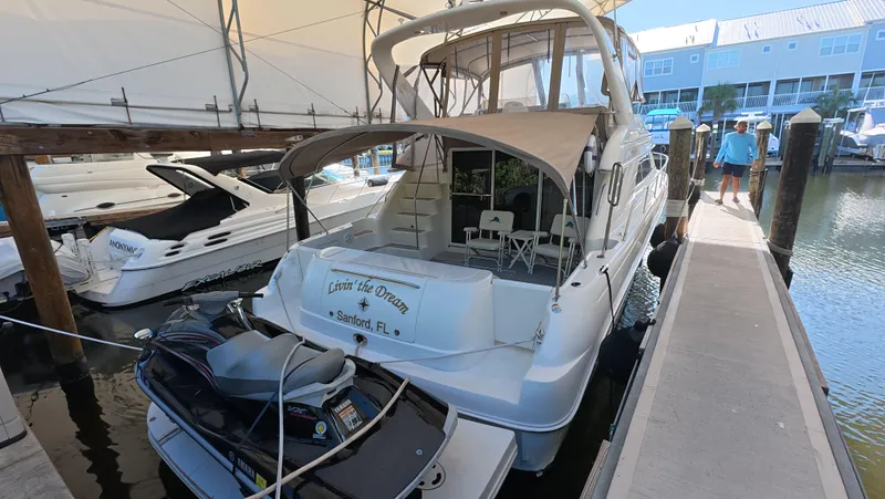 Livin' The Dream Yacht Photos Pics 2001 Sea Ray 450 Express Bridge docked with jet ski, marina setting.