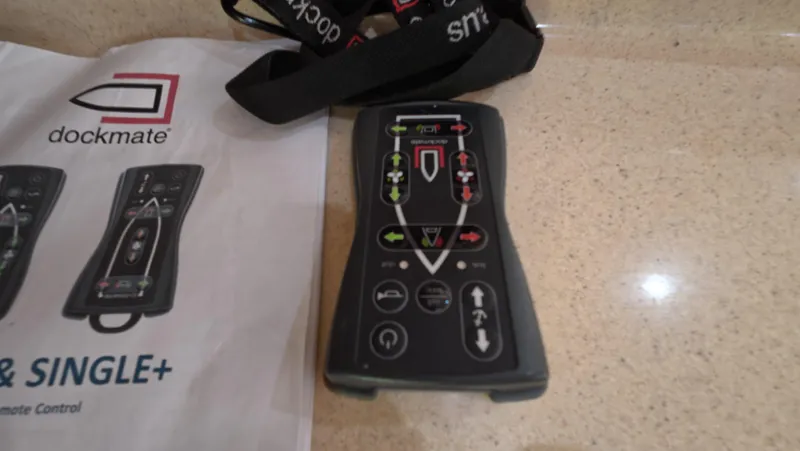 Livin' The Dream Yacht Photos Pics Dockmate remote control on a countertop, next to a manual, for Sea Ray 450 Express Bridge.