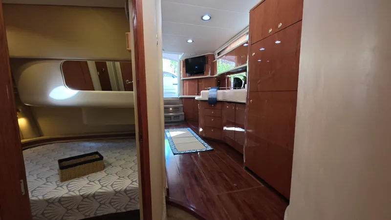 Livin' The Dream Yacht Photos Pics Interior of 2001 Sea Ray 450 Express Bridge with wood cabinetry and cozy bedroom.