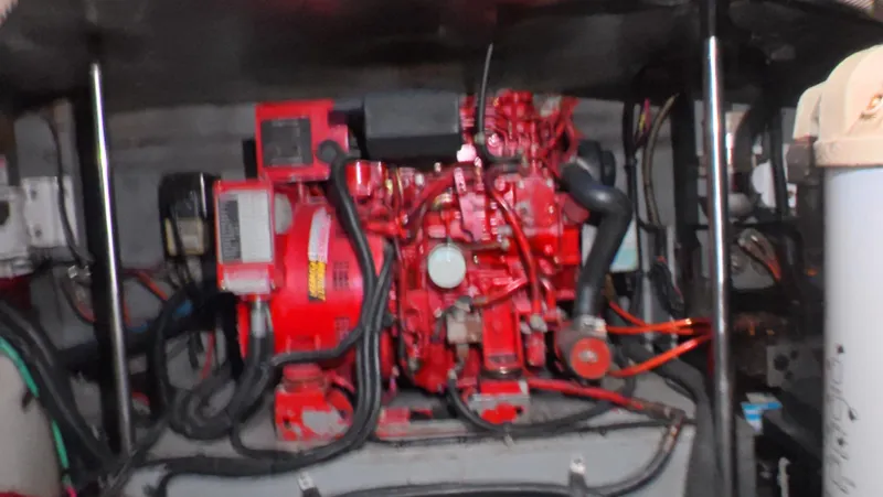 Livin' The Dream Yacht Photos Pics Engine room of a 2001 Sea Ray 450 Express Bridge with red machinery and cables.