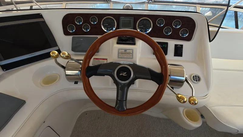 Livin' The Dream Yacht Photos Pics 2001 Sea Ray 450 Express Bridge helm with wood steering wheel and control panel.