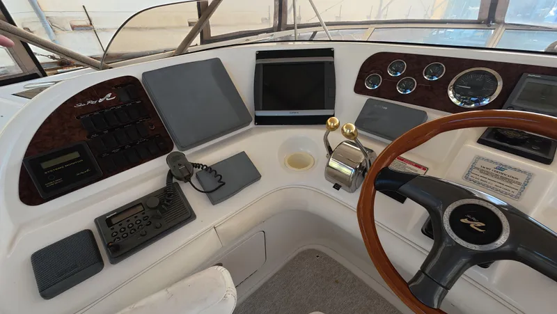 Livin' The Dream Yacht Photos Pics Control panel of a 2001 Sea Ray 450 Express Bridge yacht with steering wheel and navigation instruments.