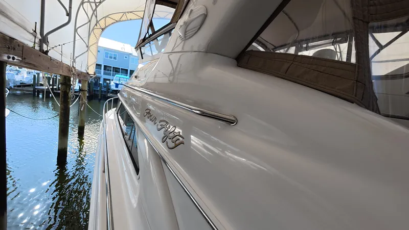 Livin' The Dream Yacht Photos Pics 2001 Sea Ray 450 Express Bridge docked under a canopy at a marina.
