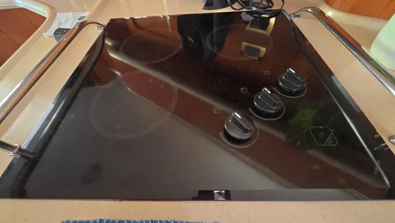 Livin' The Dream Yacht Photos Pics Stovetop on 2001 Sea Ray 450 Express Bridge yacht, featuring sleek black design and control knobs.