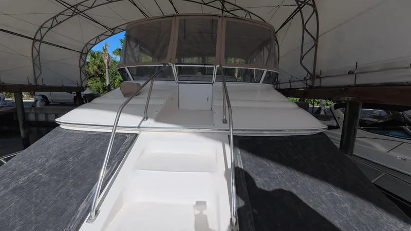 Livin' The Dream Yacht Photos Pics 2001 Sea Ray 450 Express Bridge yacht under canopy, front view with stairs and railing.