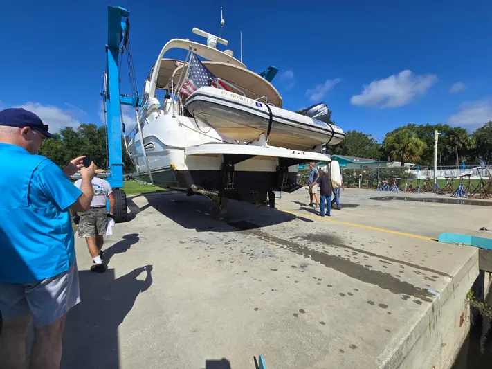 Livin' The Dream Yacht Photos Pics 2001 Sea Ray 450 Express Bridge yacht being lifted at a marina with onlookers.
