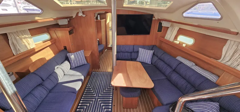  Yacht Photos Pics Interior of 2005 Hunter 456 yacht with blue seating and wooden accents.
