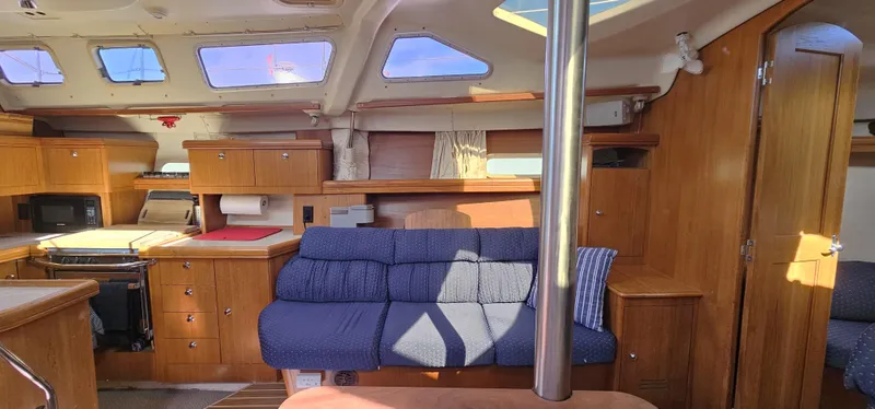  Yacht Photos Pics Interior of a 2005 Hunter 456 yacht with wooden cabinetry and blue seating.