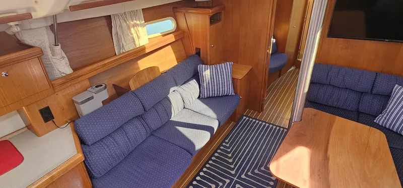  Yacht Photos Pics Interior of a 2005 Hunter 456 yacht with blue seating and wooden finishes.