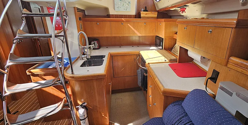  Yacht Photos Pics Interior of 2005 Hunter 456 yacht, featuring a well-equipped kitchen with wooden cabinetry and stainless steel fixtures.