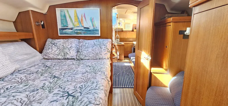  Yacht Photos Pics Cozy cabin interior of 2005 Hunter 456 sailboat with bed and nautical decor.