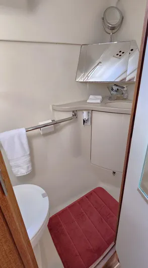  Yacht Photos Pics Compact bathroom in a 2005 Hunter 456 yacht, featuring a mirror, sink, and red mat.