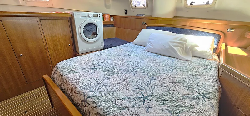  Yacht Photos Pics Cozy bedroom in 2005 Hunter 456 yacht with bed, washer, and wooden cabinetry.