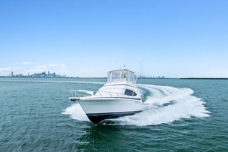 Mr. Bond Yacht Photos Pics 2006 Bertram 39 Convertible yacht cruising on open water with city skyline backdrop.