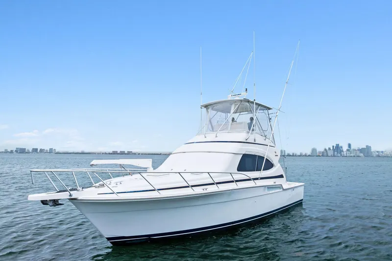 Mr. Bond Yacht Photos Pics 2006 Bertram 39 Convertible yacht on calm water with city skyline in background.