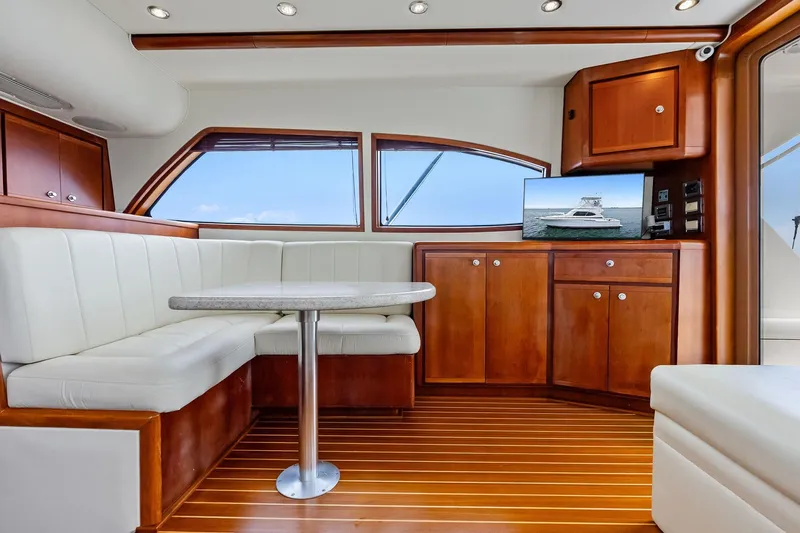 Mr. Bond Yacht Photos Pics Luxurious interior of 2006 Bertram 39 Convertible yacht with wood cabinetry and white seating.