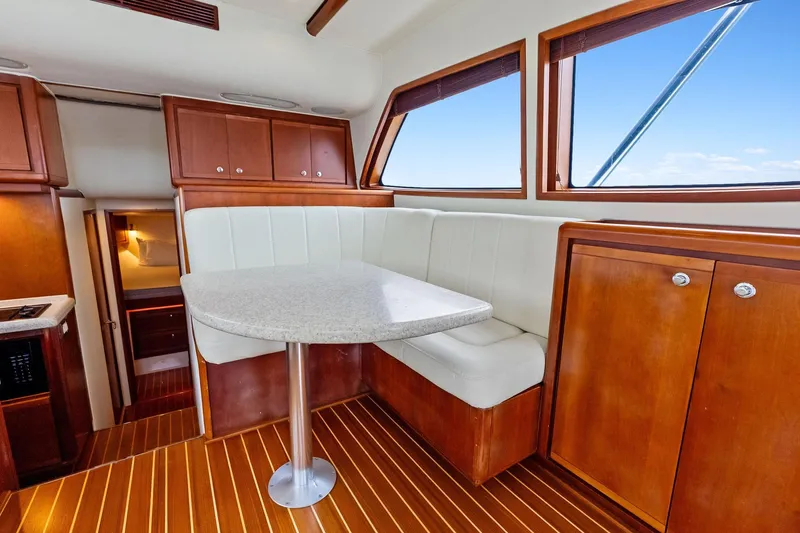Mr. Bond Yacht Photos Pics Interior of 2006 Bertram 39 Convertible yacht with wooden cabinetry and white seating.