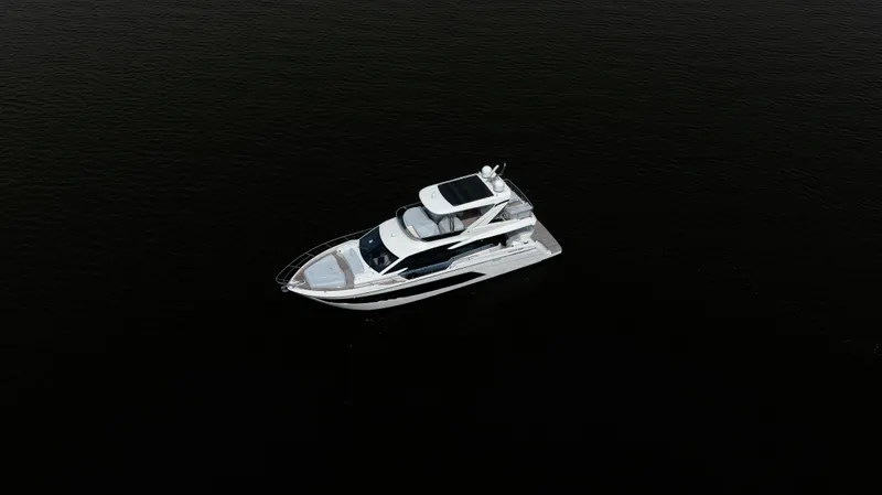  Yacht Photos Pics Aerial view of 2022 Absolute 62 Fly yacht on dark water.