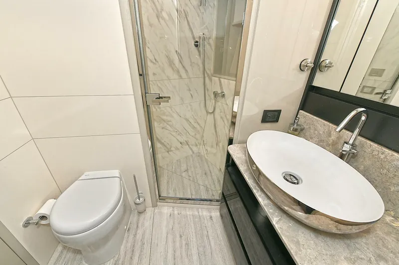  Yacht Photos Pics Luxurious bathroom in 2022 Absolute 62 Fly yacht with modern fixtures and marble accents.