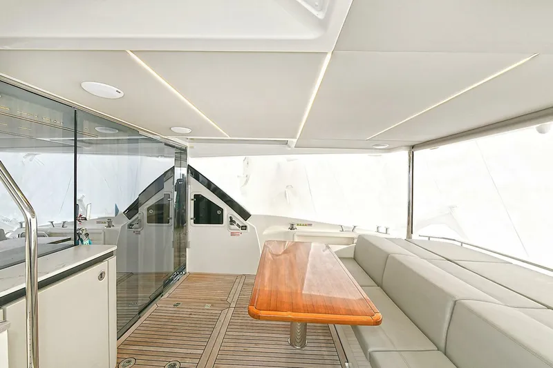  Yacht Photos Pics Luxurious interior of 2022 Absolute 62 Fly yacht with sleek seating and wooden table.