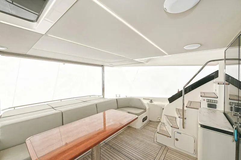  Yacht Photos Pics Luxurious interior of 2022 Absolute 62 Fly yacht with elegant seating and wooden table.