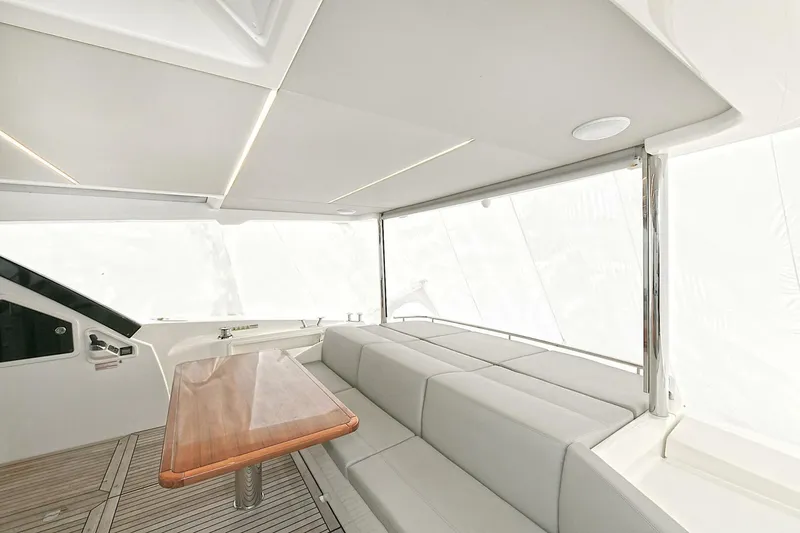  Yacht Photos Pics Luxurious interior of 2022 Absolute 62 Fly yacht with sleek seating and wooden table.