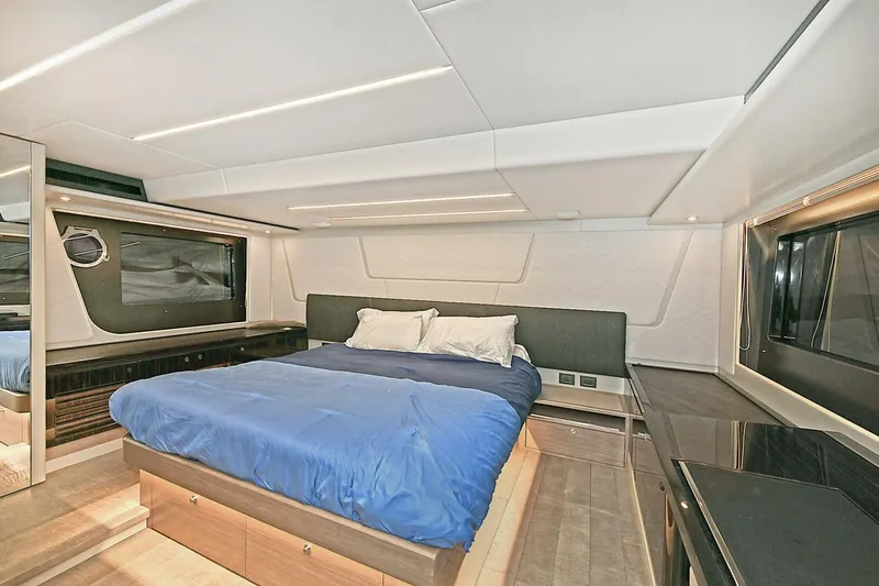  Yacht Photos Pics Luxurious bedroom interior of 2022 Absolute 62 Fly yacht with modern design and blue bedding.