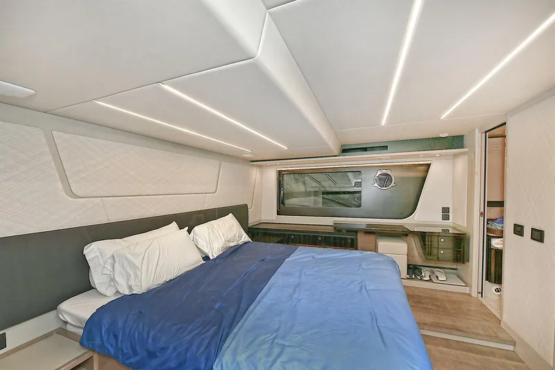  Yacht Photos Pics Luxurious bedroom interior of 2022 Absolute 62 Fly yacht with modern design and blue bedding.