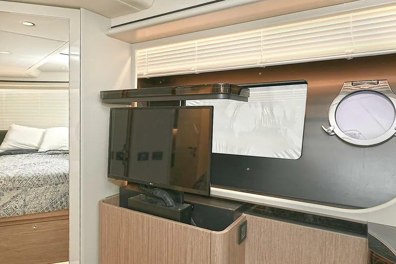  Yacht Photos Pics Interior of 2022 Absolute 62 Fly yacht with TV, porthole, and bedroom view.