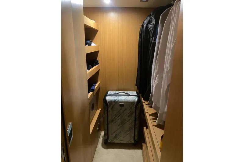  Yacht Photos Pics Walk-in closet on 2011 Sanlorenzo SL62 yacht with shelves, hanging clothes, and suitcase.