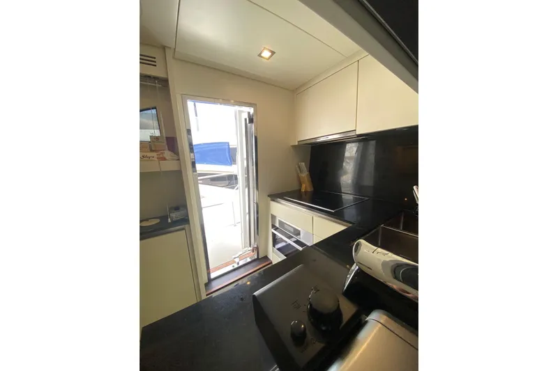  Yacht Photos Pics Compact kitchen interior of 2011 Sanlorenzo SL62 yacht with modern appliances and outdoor access.
