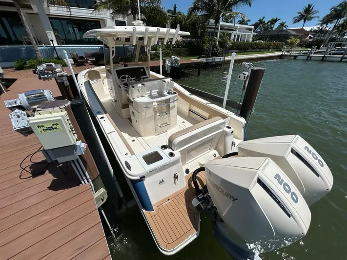  Yacht Photos Pics 2023 Scout 277 LXF boat docked, featuring dual Mercury engines and spacious deck.