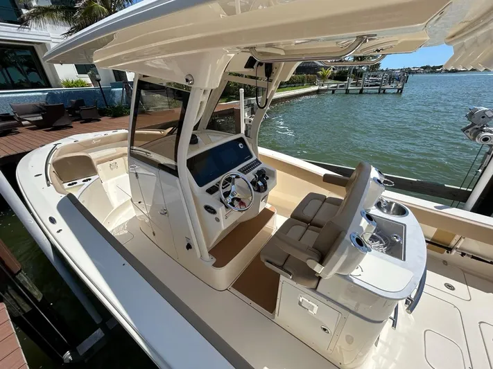  Yacht Photos Pics 2023 Scout 277 LXF boat with modern helm, docked by waterfront.