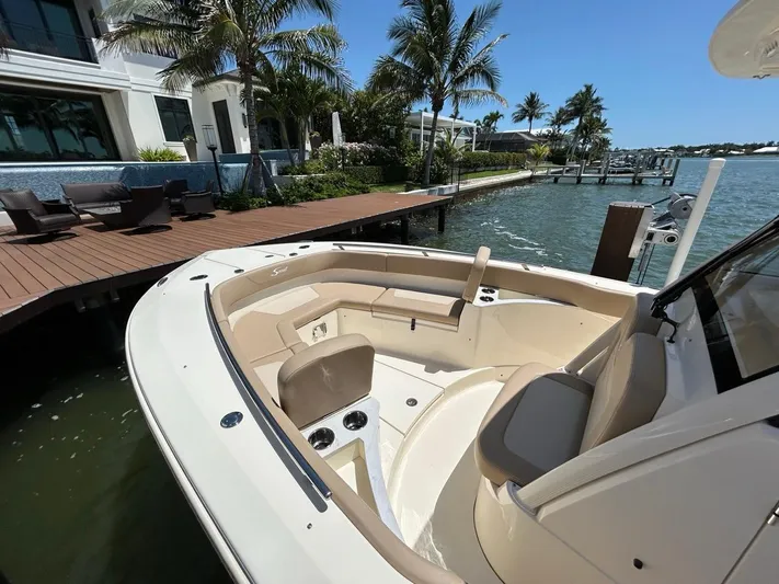  Yacht Photos Pics 2023 Scout 277 LXF boat docked by a waterfront home with palm trees.