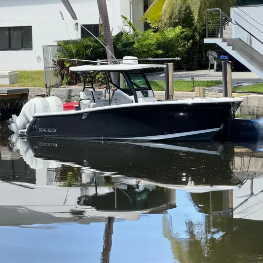  Yacht Photos Pics 2019 Blackfin 272 CC boat docked on calm water, reflecting surroundings.