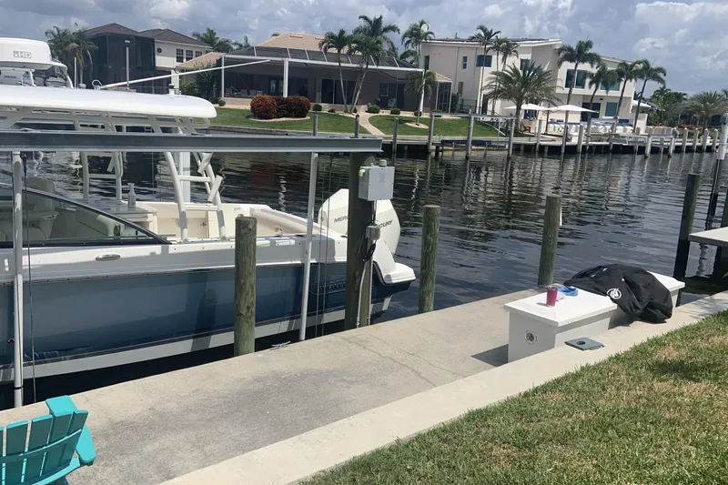  Yacht Photos Pics 2019 Boston Whaler 270 Vantage docked by waterfront homes with palm trees.