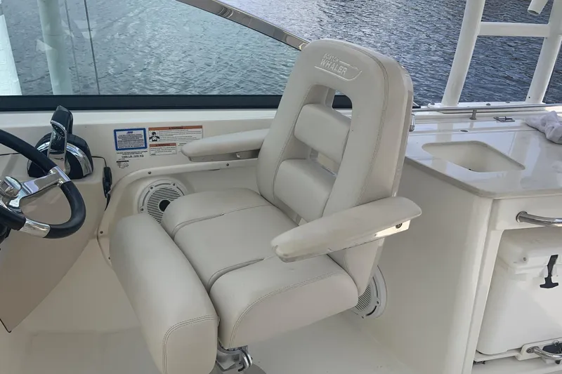 Yacht Photos Pics Captain's chair on 2019 Boston Whaler 270 Vantage boat, featuring luxurious white upholstery.