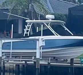  Yacht Photos Pics 2019 Boston Whaler 270 Vantage boat docked near a waterfront home.