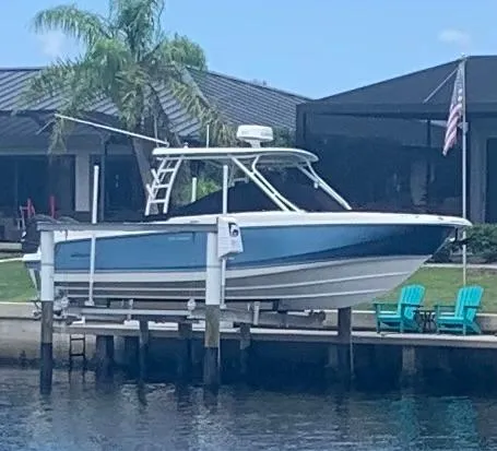  Yacht Photos Pics 2019 Boston Whaler 270 Vantage boat docked near waterfront home with palm tree.