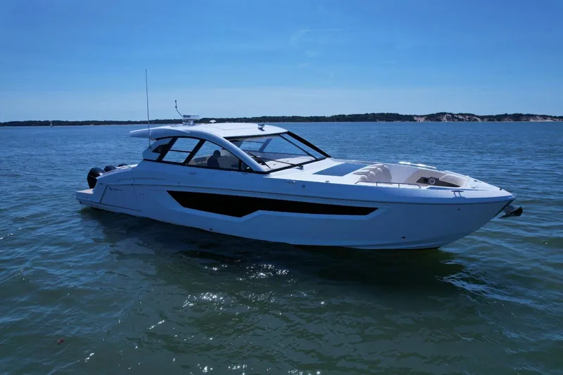  Yacht Photos Pics 2024 Cruisers Yachts 50 GLS luxury boat on calm water under clear blue sky.