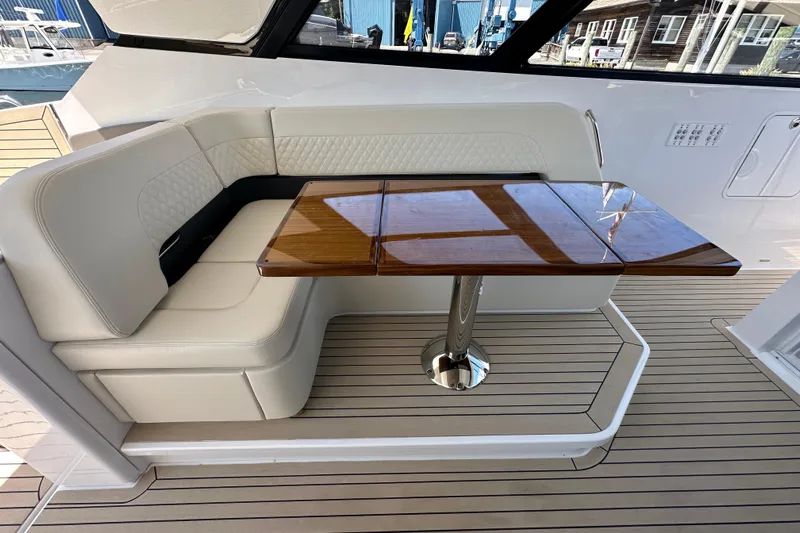  Yacht Photos Pics Luxurious seating area with wooden table on 2024 Cruisers Yachts 50 GLS.