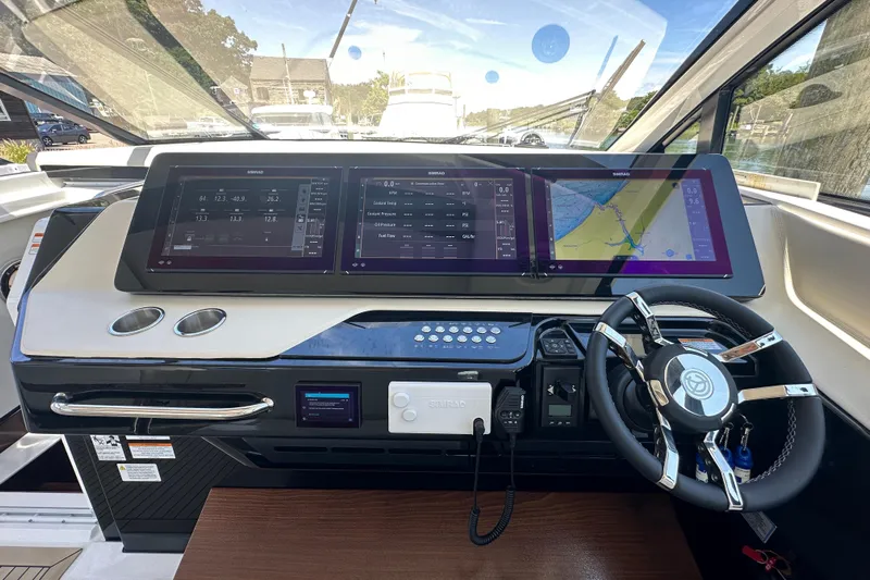  Yacht Photos Pics 2024 Cruisers Yachts 50 GLS helm with advanced navigation displays and modern steering wheel.